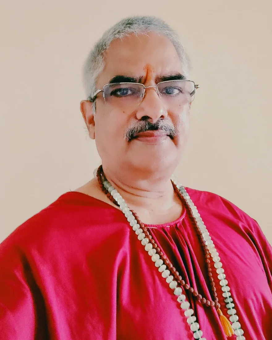 Shrawan Mishra (Swami Anant Chaitanya), astrology and vastu consultant, wearing a crimson kurta with rudraksha and crystal malas
